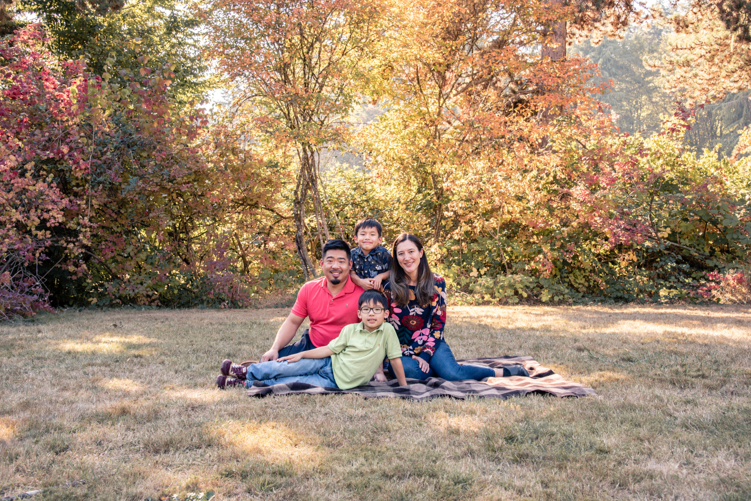 a family on a blanket at seward park in the fall
