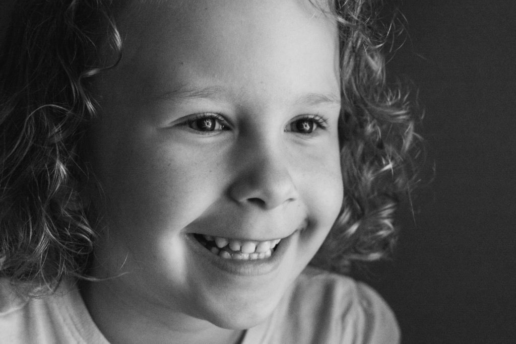 close up black and white photo of a girl smiling