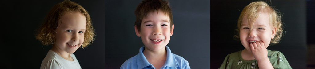 three kids on dark backgrounds smiling